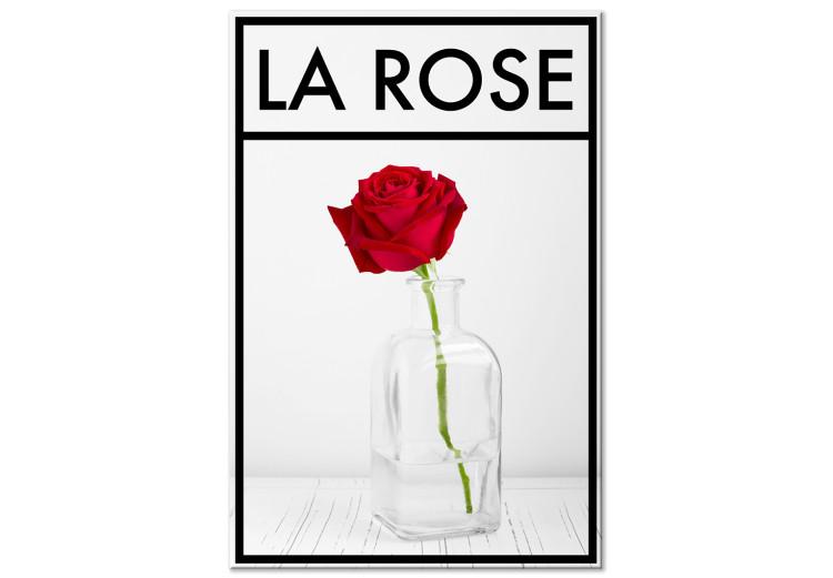 Leinwandbild Die Rose – Eine intensiv rote Rosenblüte in einer Vase auf hellgrauem Hintergrund mit schwarzem Rahmen und einer französischen Aufschrift