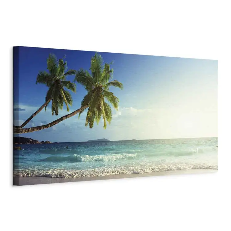 Tropischer Strand - Palmen am Meeresufer unter blauem Himmel